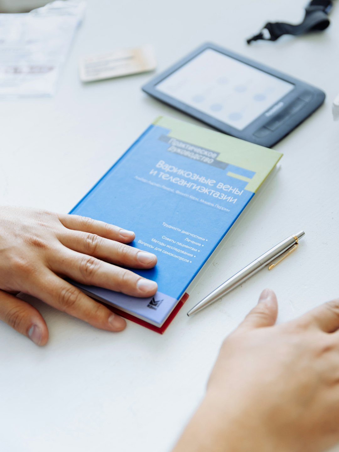 a-persons-hand-on-a-blue-folder-next-to-a-tablet-innu-y-voc